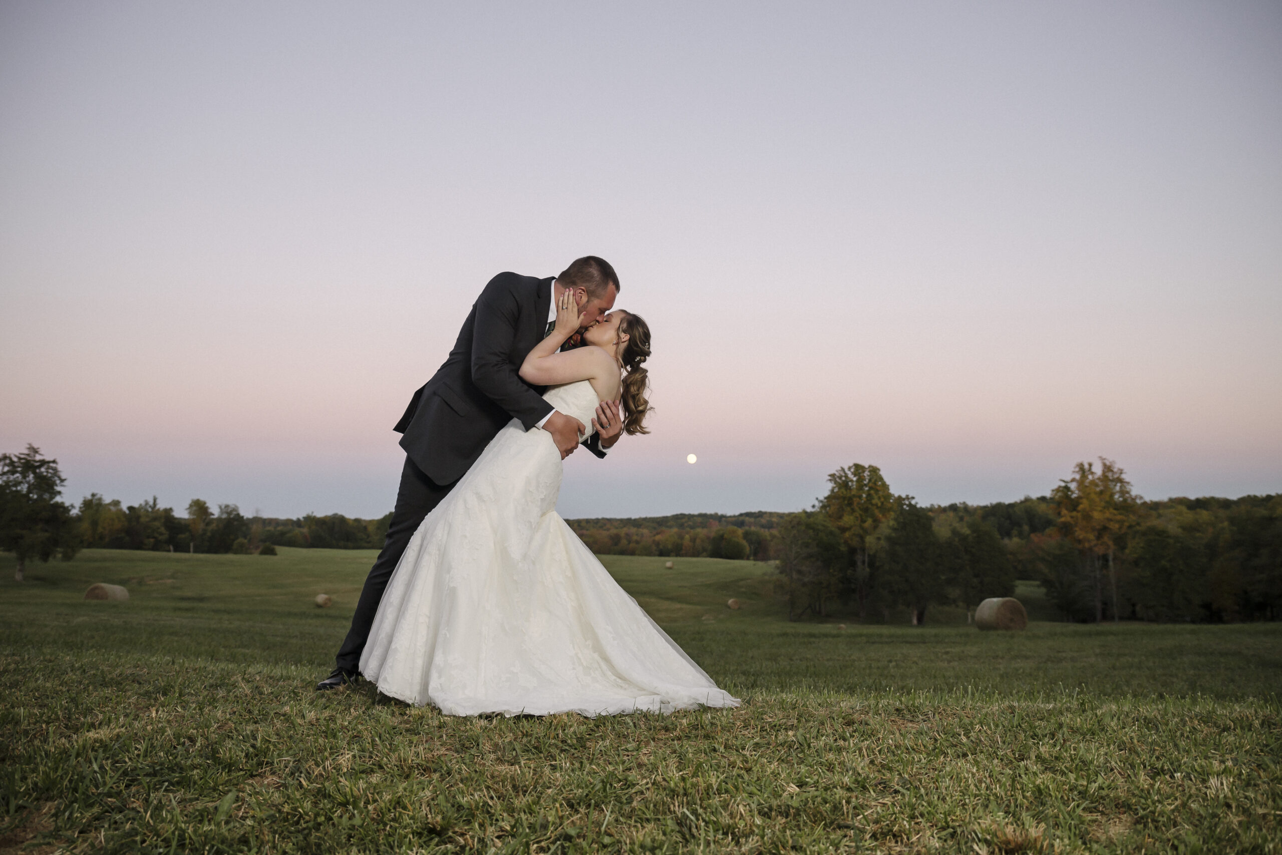 Bride and groom kiss at sunset